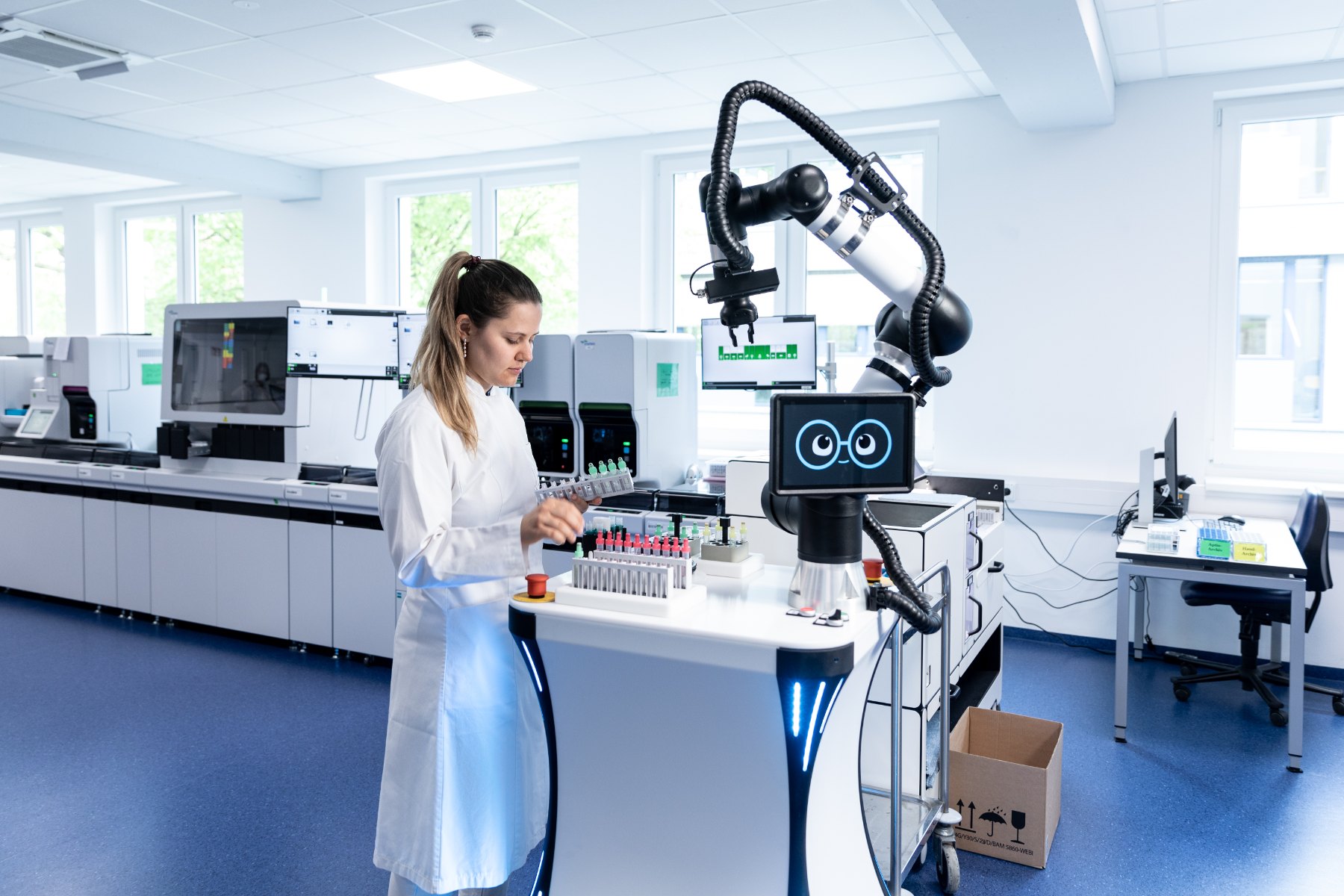 uLab Mobile in laboratory operation: the robot arm handles sample tubes while a laboratory employee continues working at the same bench.